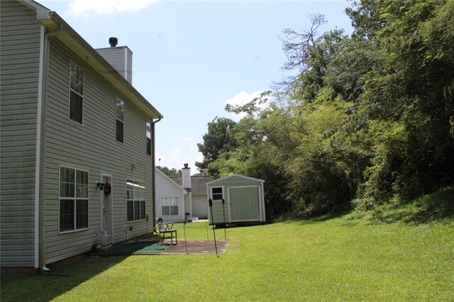 view of yard with a storage shed and a patio area