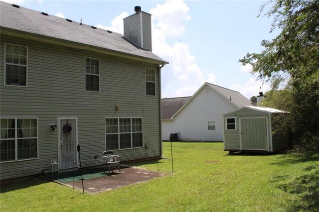 back of house with a yard, a patio area, and a storage unit