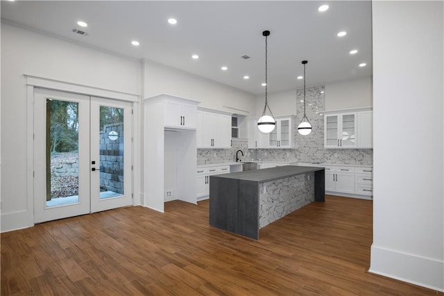 kitchen with white cabinetry, a center island, french doors, pendant lighting, and decorative backsplash