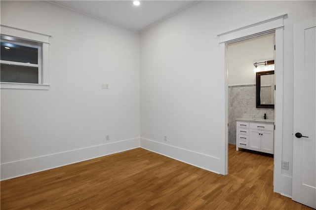 unfurnished bedroom featuring connected bathroom and light hardwood / wood-style floors