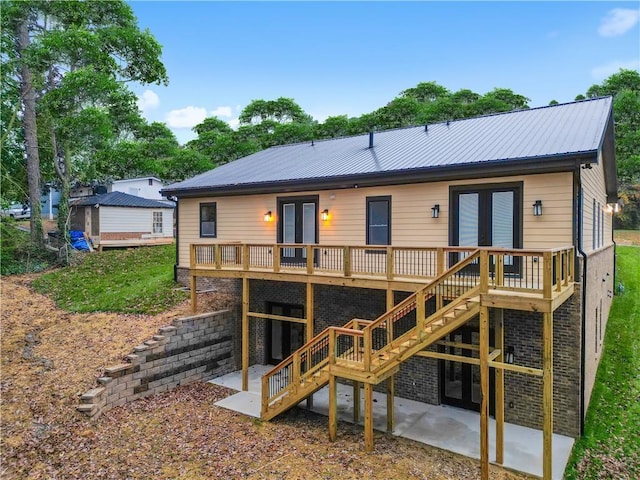 back of house with a patio, a wooden deck, and french doors