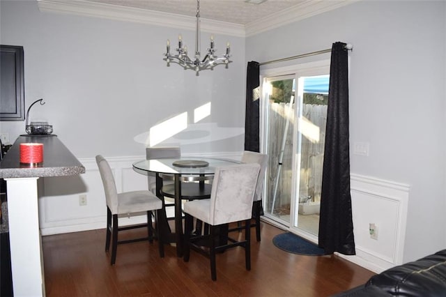 dining room featuring ornamental molding, dark wood-type flooring, and an inviting chandelier