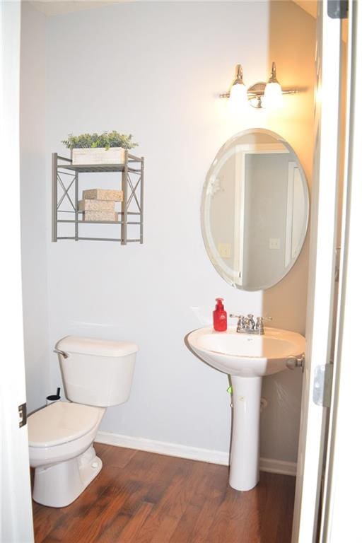 bathroom with hardwood / wood-style flooring and toilet