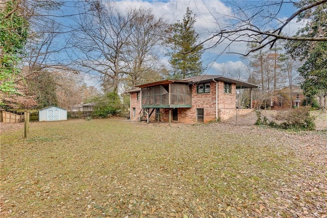 rear view of property with a yard, a shed, and a sunroom