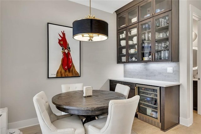 dining area featuring wine cooler, bar, and light hardwood / wood-style floors