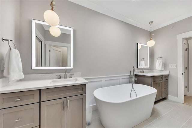 bathroom with a washtub, vanity, and tile patterned floors