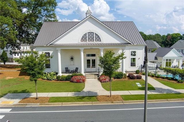 view of front of property featuring covered porch and a front lawn