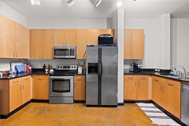 kitchen with light tile patterned floors, stainless steel appliances, light brown cabinetry, and sink