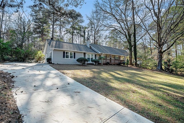 ranch-style house featuring covered porch and a front lawn