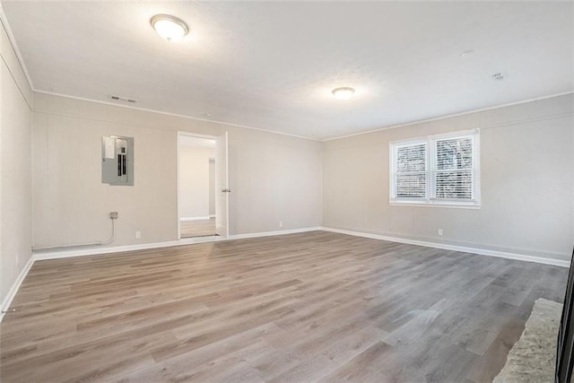 spare room featuring electric panel and wood-type flooring