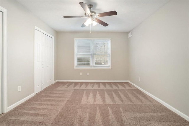 unfurnished bedroom featuring ceiling fan, a closet, and carpet