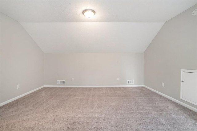 bonus room with light carpet and lofted ceiling