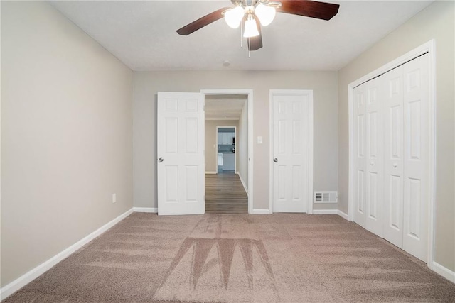 unfurnished bedroom with ceiling fan and light colored carpet