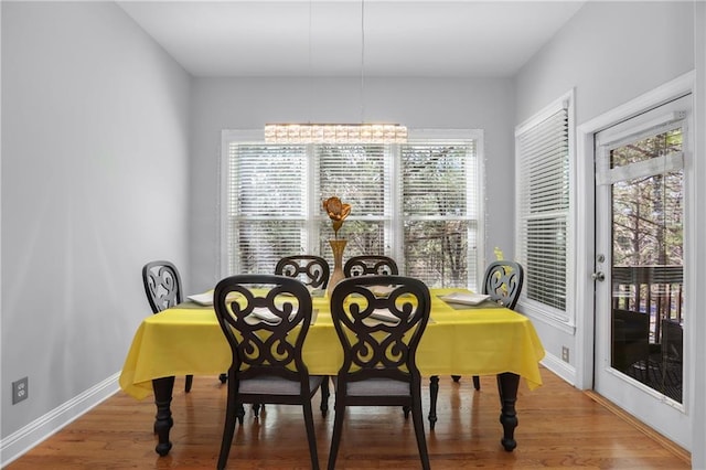 dining space featuring wood finished floors and baseboards