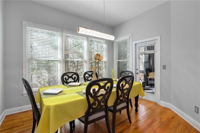 dining area featuring light wood-style floors and baseboards