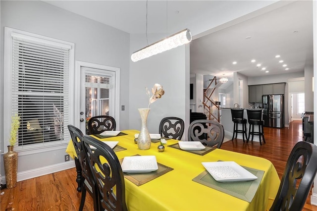 dining area with dark wood-style floors, baseboards, stairs, and recessed lighting