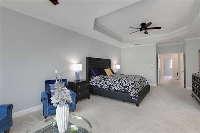 bedroom featuring a tray ceiling, crown molding, and baseboards