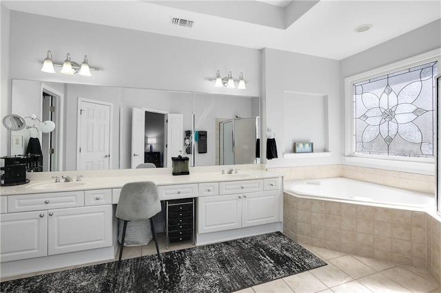 bathroom with double vanity, visible vents, tile patterned floors, a shower stall, and a sink