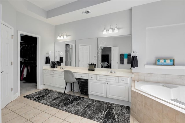 bathroom featuring double vanity, tile patterned floors, visible vents, a sink, and a bath