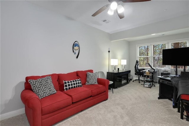 carpeted living room featuring baseboards, visible vents, and a ceiling fan