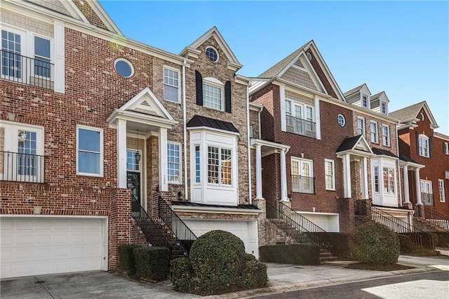 view of property with a garage, brick siding, and driveway