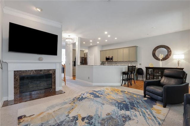 living area with a high end fireplace, crown molding, baseboards, and recessed lighting