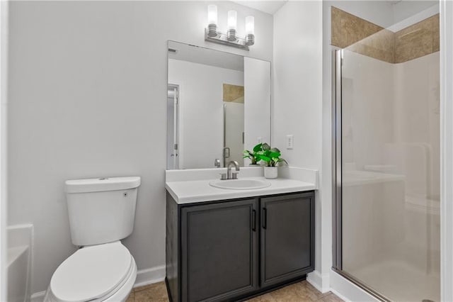 bathroom featuring tile patterned floors, vanity, a shower with shower door, and toilet