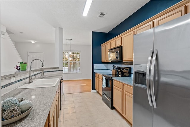 kitchen featuring black appliances, sink, light hardwood / wood-style flooring, light brown cabinetry, and decorative light fixtures