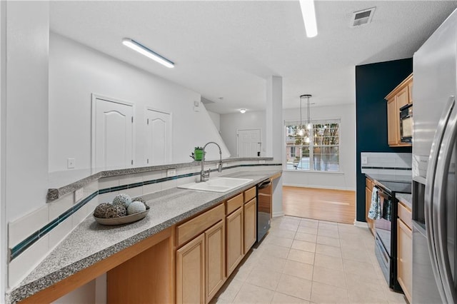 kitchen with black appliances, sink, hanging light fixtures, tasteful backsplash, and light tile patterned flooring