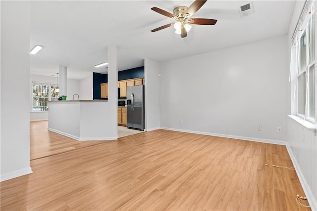 unfurnished living room featuring light hardwood / wood-style flooring and ceiling fan