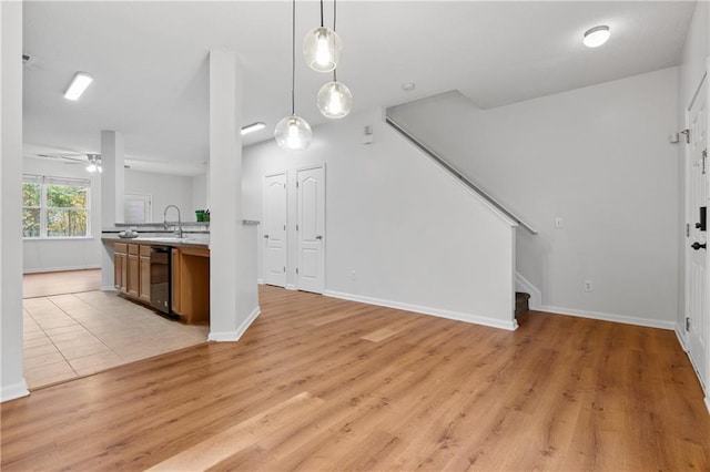 kitchen featuring pendant lighting, light hardwood / wood-style floors, ceiling fan, and sink