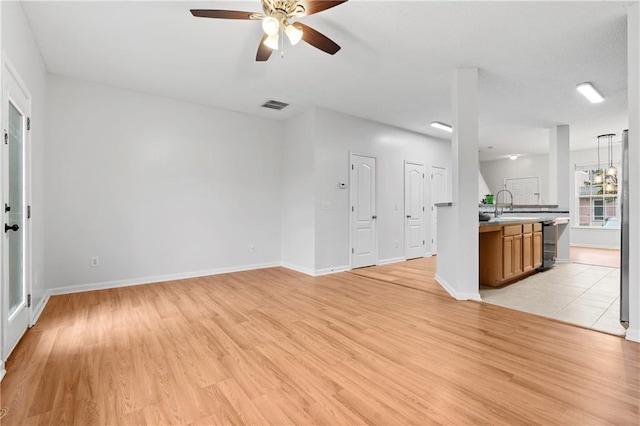 unfurnished living room featuring ceiling fan, sink, and light hardwood / wood-style floors