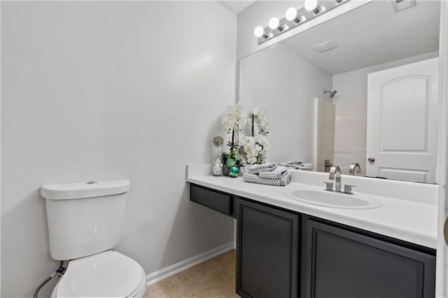 bathroom featuring toilet, vanity, tile patterned floors, and walk in shower