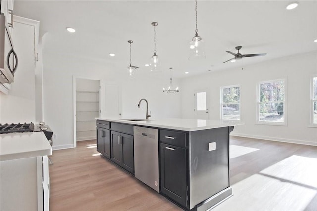 kitchen with dishwasher, decorative light fixtures, an island with sink, ceiling fan with notable chandelier, and sink