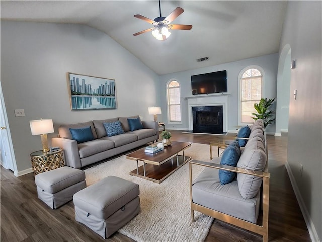 living room featuring lofted ceiling, wood-type flooring, a fireplace, and ceiling fan