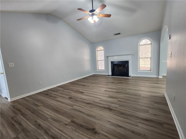 unfurnished living room with ceiling fan, a wealth of natural light, a fireplace, and dark hardwood / wood-style floors