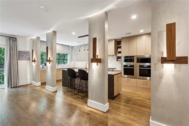 kitchen with light countertops, a healthy amount of sunlight, light wood-style flooring, and modern cabinets