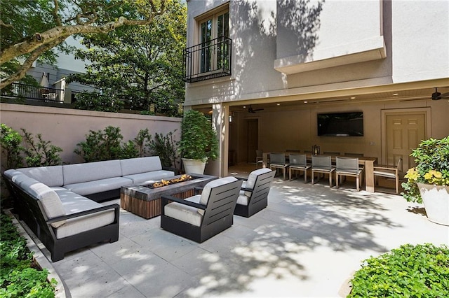 view of patio / terrace with a balcony, outdoor dining area, and an outdoor living space with a fire pit