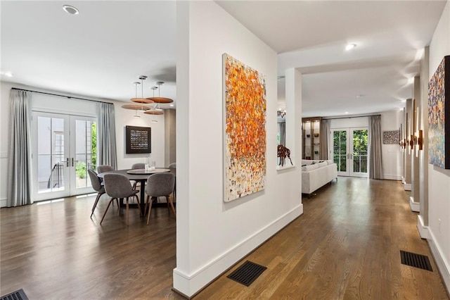 hallway featuring visible vents, wood finished floors, and french doors