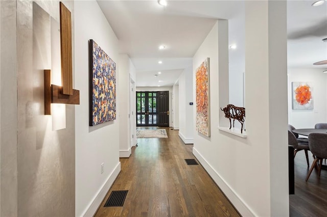 hall featuring baseboards, visible vents, dark wood finished floors, and recessed lighting