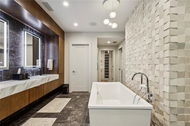 full bathroom featuring marble finish floor, a closet, visible vents, a freestanding bath, and vanity