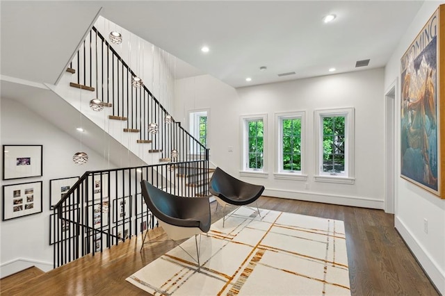 living area with recessed lighting, wood finished floors, visible vents, baseboards, and stairway