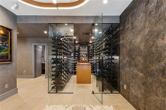 wine cellar featuring tile patterned flooring and a tray ceiling