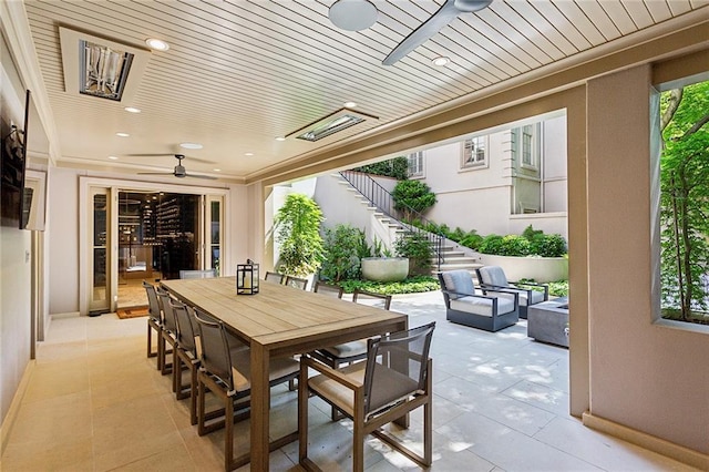 view of patio / terrace featuring an outdoor living space, outdoor dining area, ceiling fan, and stairway