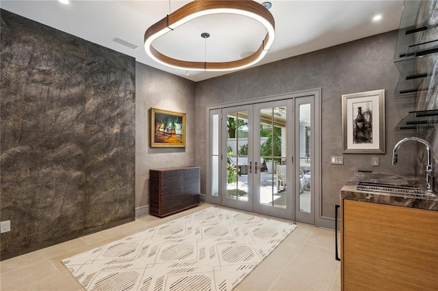 entryway featuring french doors, visible vents, a sink, and light tile patterned floors