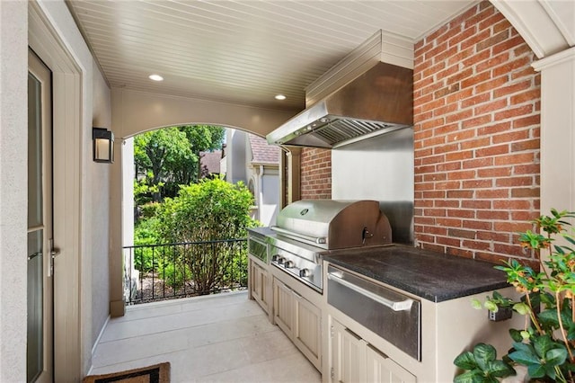 view of patio with exterior kitchen and a grill