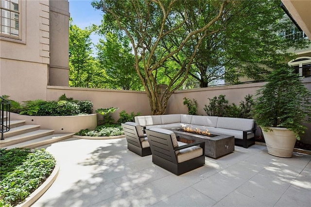 view of patio / terrace with a fenced backyard and an outdoor living space with a fire pit