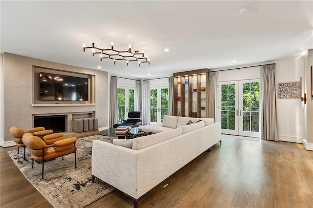 living room with french doors, a fireplace, recessed lighting, wood finished floors, and baseboards