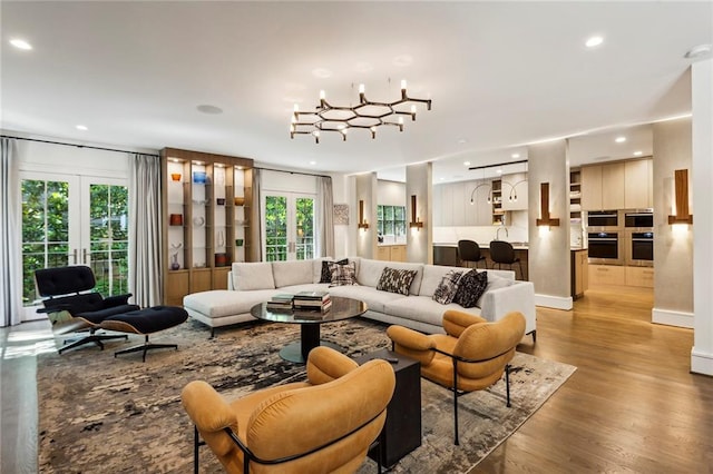 living room with recessed lighting, light wood-style flooring, and french doors