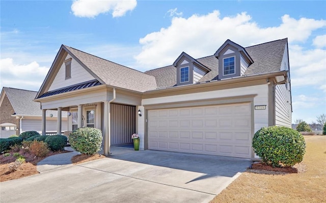 view of front of home with concrete driveway, a garage, and a shingled roof